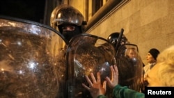 Rendőrök torlaszolják el a tüntetők elől az egyik utcát Tbilisziben 2023. március 7-én