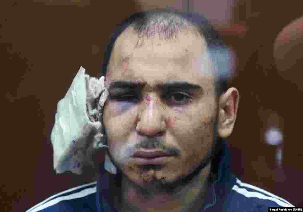 Rajabalizoda pred sudom 24. marta sa krpom preko desnog uha i natečenim licem.