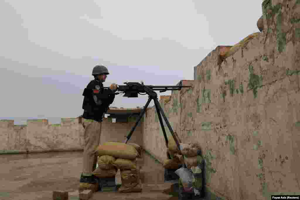 A policeman mans a 12.7-mm infantry machine gun on top of the&nbsp;Sarband police station. Recently, a senior police officer was ambushed and killed outside a police station during a firefight with militants, who, according to Shah, used thermal goggles to target the officer in the darkness.