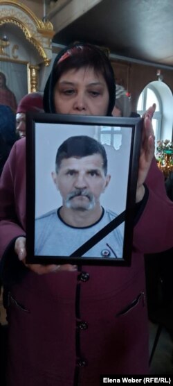 Женщина держит фотографию 60-летнего Виктора Деревянко, одного из 45 шахтёров, погибших в результате взрыва на шахте имени Костенко. Караганда, 31 октября 2023 года