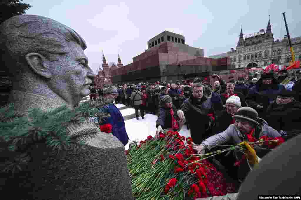 Communist Party supporters line up to place flowers at Josef Stalin&#39;s grave near the Kremlin Wall to mark the 71st anniversary of his death with the mausoleum of Soviet founder Vladimir Lenin in the background in Red Square in Moscow on March 5.