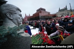 Communist Party supporters line up to place flowers at Josef Stalin's grave near the Kremlin Wall to mark the 71st anniversary of his death with the Mausoleum of the Soviet founder Vladimir Lenin in the background, on Red Square on March 5.