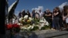 Mourners stand next to the grave in Lviv of Svitlana Lukyanchuk, a 30-year-old physician who was killed in the suspected Russian missile strike on Kyiv's Okhmatdyt children's hospital.