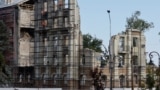 Окупаційні адміністрації конфісковують житло, призначаючи його «нічийним». На фото: робітники відновлюють зруйнований будинок, Маріуполь, серпень 2023 року
