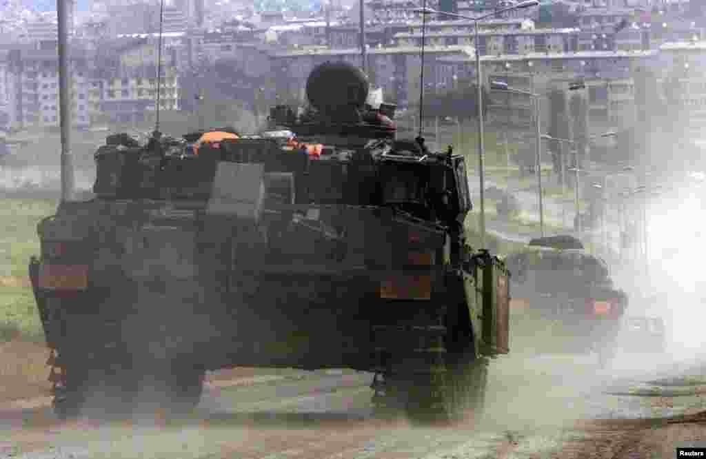 Prishtinë 13 qershor 1999: Një tank i rëndë i ushtrisë britanike i njohur me emërtimin &ldquo;Challenger&rdquo;, shihet në lagjen Veternik të Prishtinës, një ditë pas arritjes së trupave britanike në kryeqytetin e Kosovës, Prishtinë. Trupat e NATO-s nisën të marrin kontrollin e Prishtinës pas tërheqjes së trupave të ushtrisë dhe policisë së Serbisë. &nbsp; 5 qershor 2024: Kjo rrugë ka ndryshuar krejtësisht. Përveçse është zgjeruar rruga, janë ndërtuar qindra objekte afariste dhe banimi. Megjithatë, rruga dhe lagjja janë lehtësisht të identifikueshme për shkak se disa objekte në sfond vazhdojnë të jenë ende aty. 