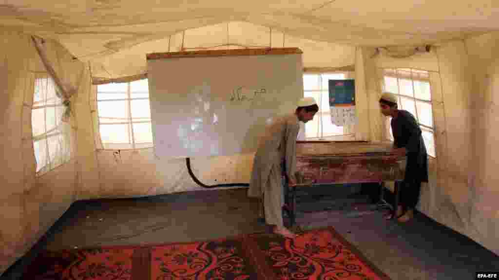 Workers move a desk at an empty educational facility setup in Kandahar, Afghanistan, by UNICEF after it was closed on the order of the Taliban government. UNICEF and other international organizations have suspended all literacy education classes in Kandahar and Helmand due to the Taliban&#39;s ban on their activities.