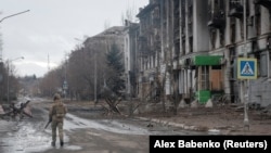 Український військовослужбовець йде порожньою вулицею у прифронтовому місті Бахмут, 21 лютого 2023 року 