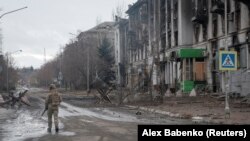 Украинский военнослужащий идет по пустой улице в прифронтовом Бахмуте, 21 февраля 2023 года