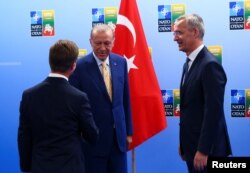 Президент Туреччини Таїп Ердоган і прем’єр-міністр Швеції Ульф Крістерссон потискають один одному руки поруч із генеральним секретарем НАТО Єнсом Столтенберґом перед зустріччю напередодні саміту НАТО у Вільнюсі, Литва, 10 липня 2023 р.