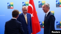 Predsednik Turske Redžep Tajip Erdogan se rukuje sa švedskim premijerom Ulfom Kristerssonom u prisustvu generalnog sekretara NATO Jensa Stoltenberga, u Viljnusu 10. jula