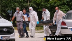 Police remove a body from the scene of an explosion in Cetinje on June 20.