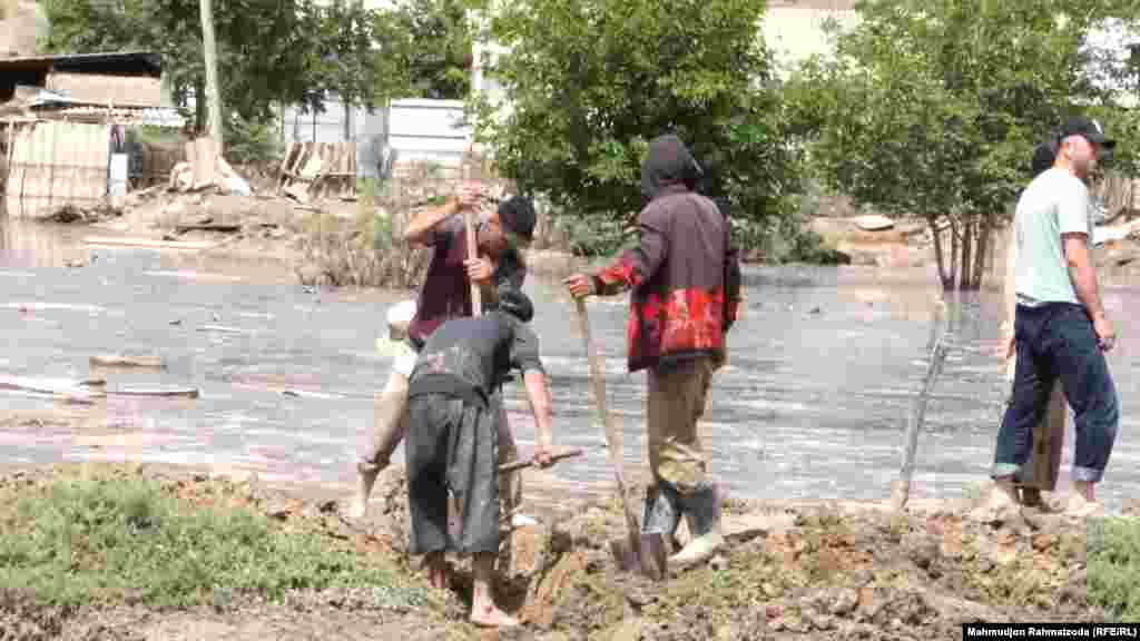 Villagers work to clear the mud. &nbsp;