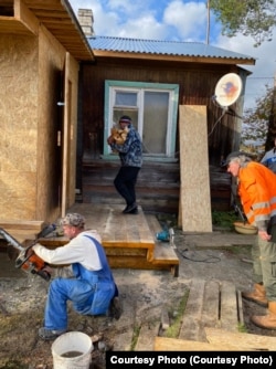 Neighbors work to repair Aleksandr Ivanovich's house in Pyalma.