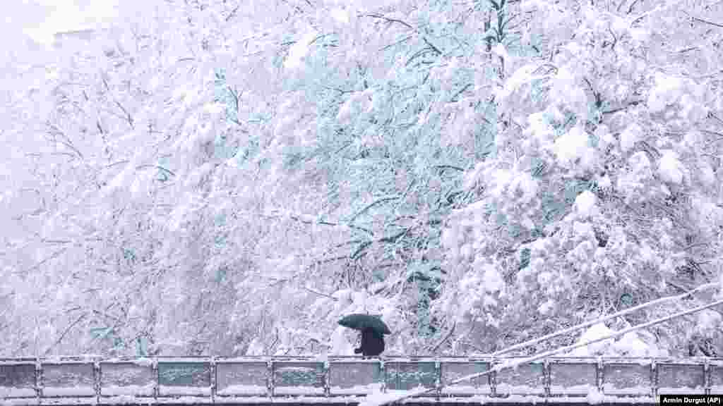 Muškarac prelazi most tokom velikih snježnih padavina u Sarajevu.