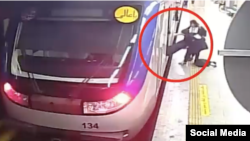 A screen shot of CCTV footage from Tehran's subway showing a girl being carried off a train by other girls and placed on the platform.