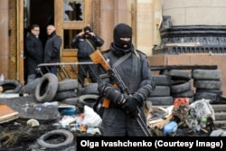 Një anëtar i maskuar i forcave speciale të Ukrainës duke qëndruar jashtë ndërtesës së administratës rajonale të Harkivit më 8 prill 2014.