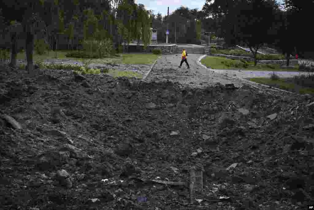 Žena prolazi pored kratera uzrokovanog ruskim raketnim napadom u Zaporižju, 8. maja 2024. &quot;Neprijatelj ne odustaje od svojih planova da Ukrajince liši još jednog masovnog napada na našu energetsku industriju&quot;, napisao je na Telegramu ukrajinski ministar energetike, German Galuščenko.