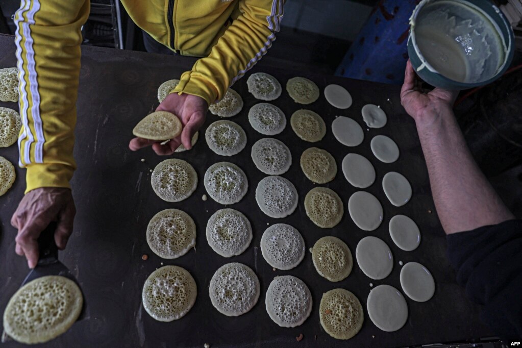 Palestinezët duke përgatitur ëmbëlsirat tradicionale 'Qatayef' për muajin e shenjtë të agjërimit të Ramazanit, në qytetin Khan Yunis në Rripin jugor të Gazës, mars 2023.