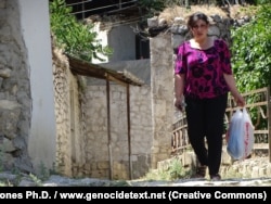 A local woman walks through Dasalti/Karintak in June 2015.