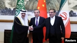 Chinese Foreign Minister Wang Yi (center) poses with Ali Shamkhani, secretary of Iran's Supreme National Security Council (right) and Saudi Arabia's national security adviser, Musaad bin Mohammed Al Aiban (left), in Beijing on March 10.