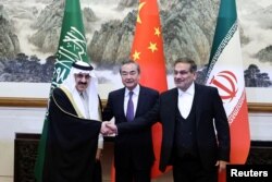 Wang Yi, Ali Shamkhani dhe Musaad bin Muhammad al-Aiban pozojnë para kamerave në Pekin më 10 mars, pasi arritën një marrëveshje për të rifilluar marrëdhëniet diplomatike mes Riadit dhe Teheranit.