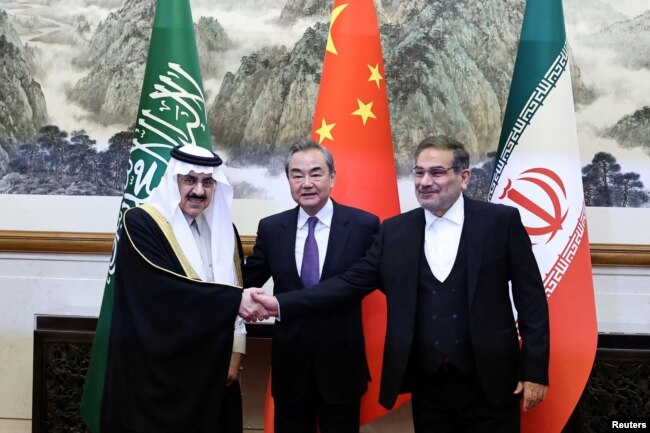Wang Yi, Ali Shamkhani dhe Musaad bin Muhammad al-Aiban pozojnë para kamerave në Pekin më 10 mars, pasi arritën një marrëveshje për të rifilluar marrëdhëniet diplomatike mes Riadit dhe Teheranit.