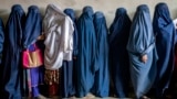 Afghan women wait to receive food rations distributed by a humanitarian aid group in Kabul in May 2023. 