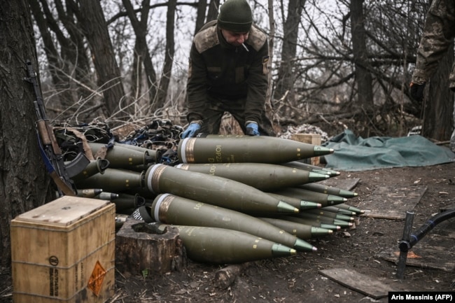 A Ukrainian serviceman prepares 155-millimeter artillery shells near Bakhmut in eastern Ukraine.