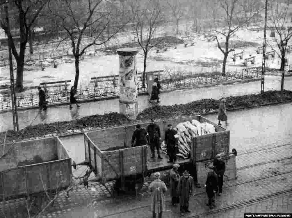 Holttestek szállítása a villamossíneken közlekedő vasúti kocsikon a pesti gettóból, 1945