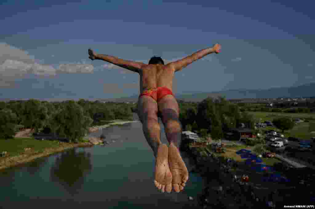 A man jumps from a bridge during an annual high-diving competition near the town of Gjakova in Kosovo.&nbsp;