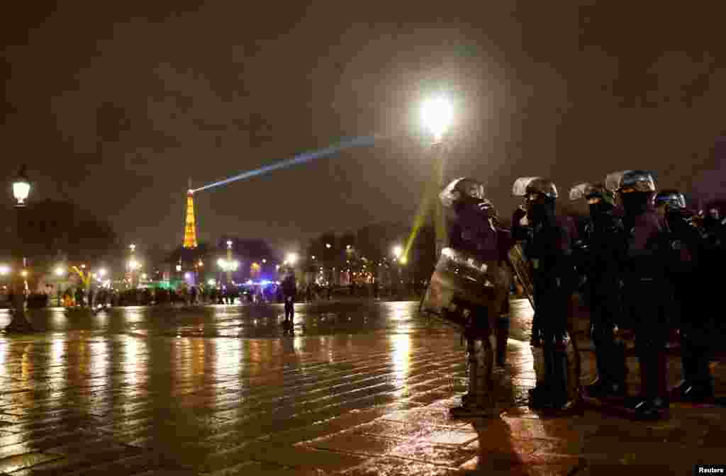 Anëtarët e xhandarmërisë franceze qëndrojnë roje në Place de la Concorde. Marshet e dhunshme të protestuesve vazhduan edhe në orët e para të 18 marsit.