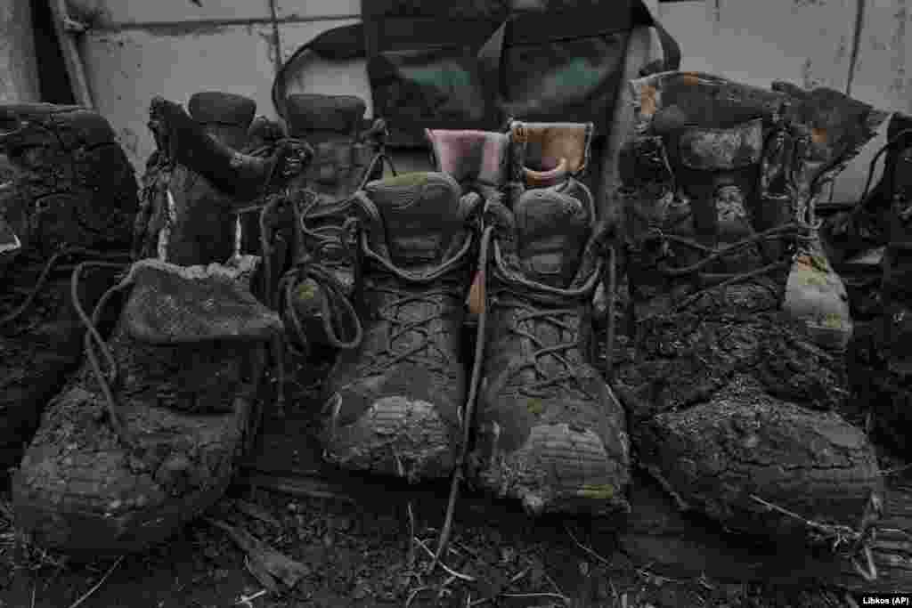 The discarded boots of wounded Ukrainian soldiers sit outside a medical stabilization point at the front line in Bakhmut. Both sides have suffered heavy casualties fighting for the largely destroyed city, which has become a symbol of Kyiv&#39;s defiance and Moscow&#39;s military failures.