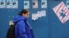 A woman walks past campaign posters for the parliamentary elections in Tehran.