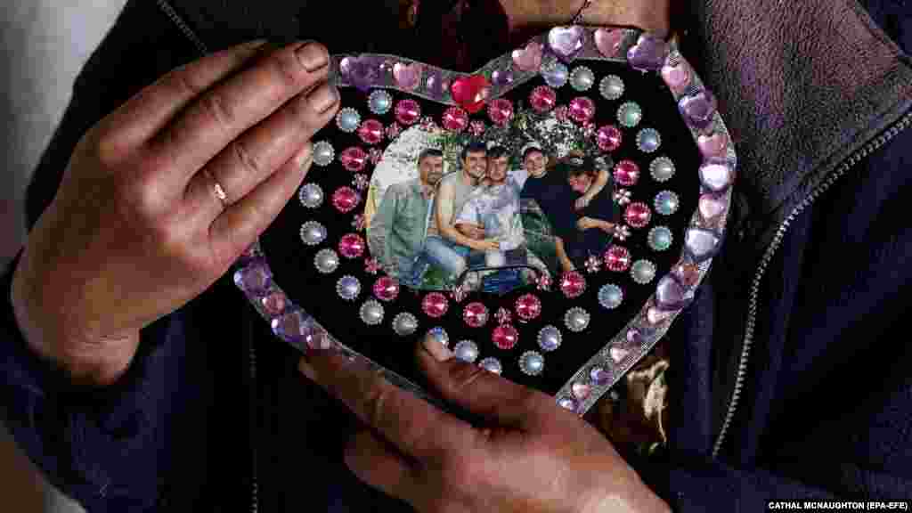 Iryna holds a treasured photograph of her five sons, showing Roman (2nd from left), who now appears in her dreams. Another son is serving in the military.