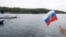 A member of Havana's Russian community held a flag as a Russian nuclear-powered submarine entered the bay of the Cuban capital in the last Russian naval visit, on June 12.