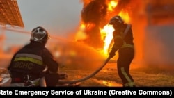 Firefighters extinguish a fire caused by falling missile debris during a Russian attack in the Kyiv region on June 12.