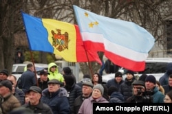 Emberek a moldovai (balra) és a gagauz zászlóval (jobbra) Nyikolaj Dudoglo beszédét hallgatják Komratban március 18-án
