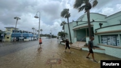 Ljudi hodaju poplavljenim ulicama nakon što je uragan Idalia prošao kroz Floridu 30. avgust