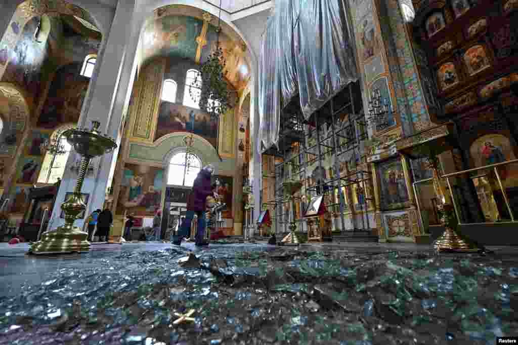 Një grua duke pastruar mbeturinat brenda një katedrale të dëmtuar nga një sulm rus me raketa në Zaporizhja, Ukrainë, më 18 tetor.