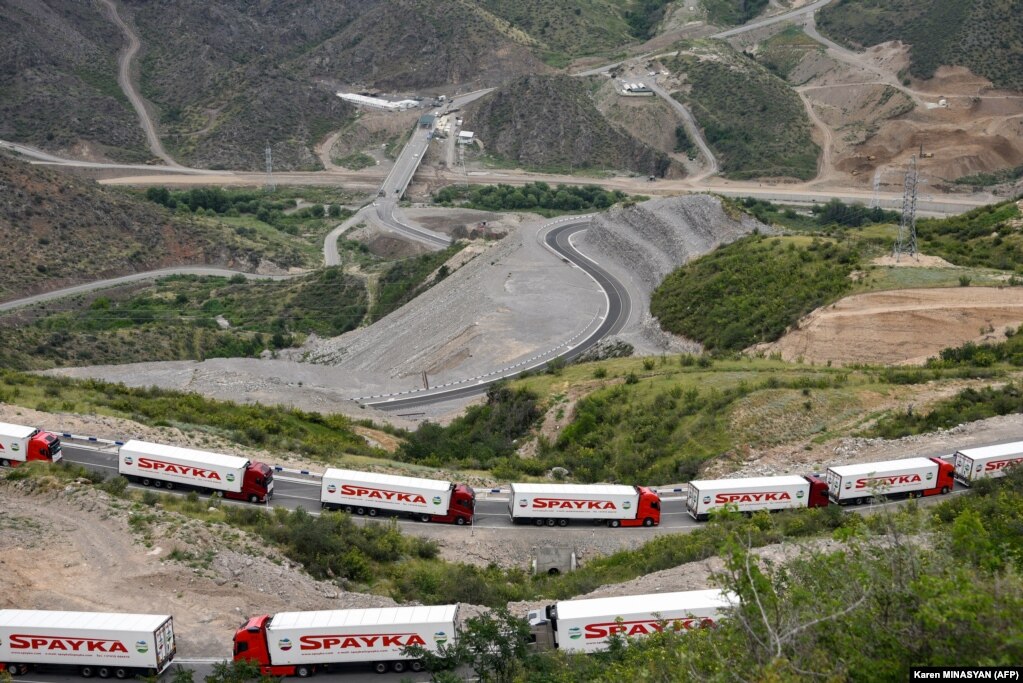 Camion armeni che trasportano aiuti umanitari per la regione separatista del Nagorno-Karabakh sono bloccati non lontano da un posto di blocco azero allestito all'ingresso del Corridoio Lacin, l'unico collegamento terrestre del Karabakh con l'Armenia, il 30 luglio.  La strada è stata bloccata dall'Azerbaigian.  più di sette mesi fa.