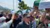 Srebrenica, Bosnia and Herzegovina -- People carrying the remains of Srebrenica genocide victims to their graves