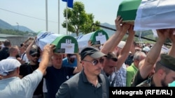 Сребреница, Босна и Херцеговина -- Луѓе носат посмртните останки на жртвите од геноцидот во Сребреница