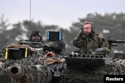 Министр обороны Германии Борис Писториус (справа) испытывает танк Leopard 2, который должен быть поставлен Украине