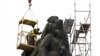 Работник демонтира част от бронзовите фигури на Паметника на съветската армия в София, 13 декември 2023 г.