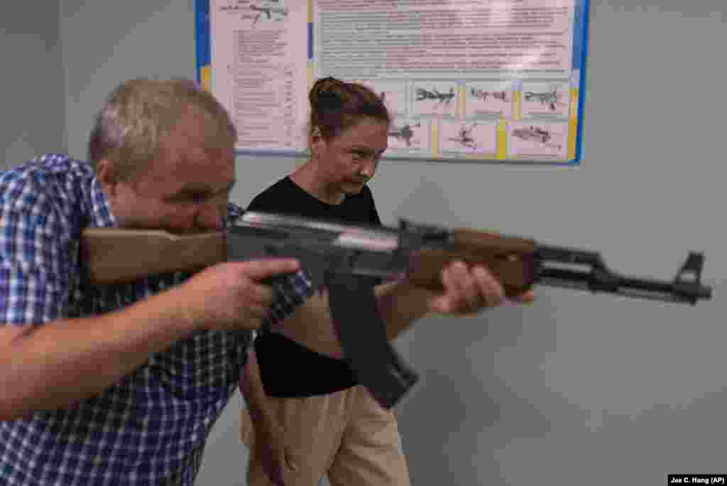 Инструктор Алексей Огиренко показывает Ирине Чудной, как нужно целиться и стрелять из автоматического оружия