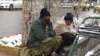 دو کارگر روزمزد در انتظار پیدا شدن کاری در گوشه‌ای از شهر هرات در یک روز سرد زمستان نشسته اند. 