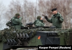 Lengyel kiképzők és ukrán katonák gyakorolnak Leopard 2A4-es harckocsikon a lengyel 10. páncélos lovasdandár bázisán, a lengyelországi Świętoszówban 2023. február 13-án