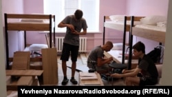 Вимушені переселенці із окупованих Росією територій облаштовують собі житло у шелтері. Запоріжжя