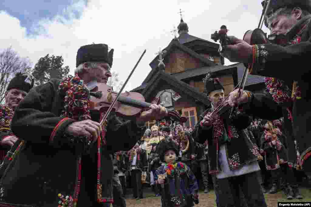 Мужчины в гуцульских костюмах играют на скрипках перед церковью. Со временем эта традиция стала частью Рождества, сейчас Колядки означают Рождество, рождение Иисуса