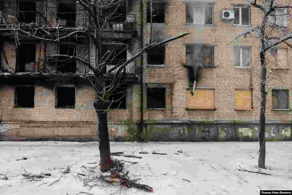 A pipe emits smoke from the wood-burning stove in Viktor Ivanovich&#39;s apartment. He is one of the few people who remain in the damaged building. &nbsp;
